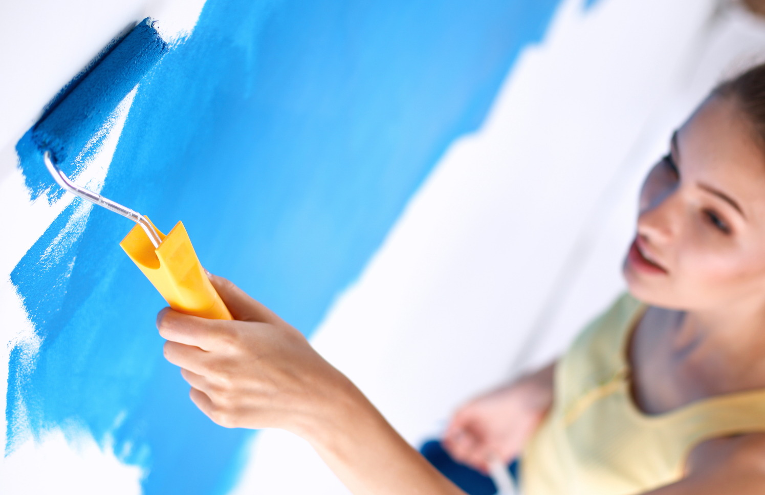 Woman repainting their house wall